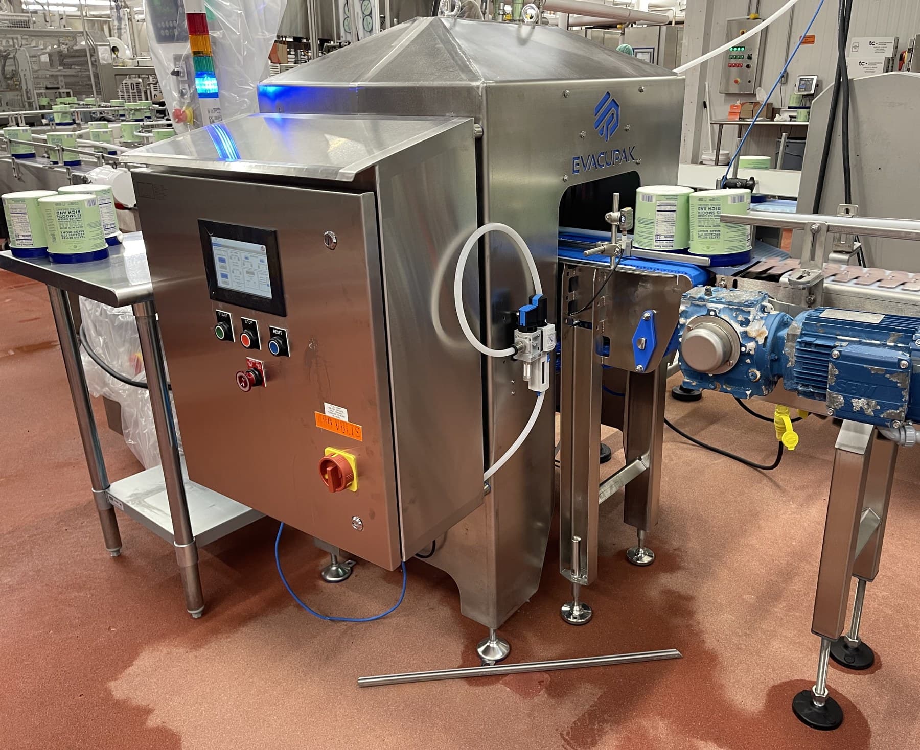 Lid-match inspection system installed on an ice cream packaging line with a reject table beside it