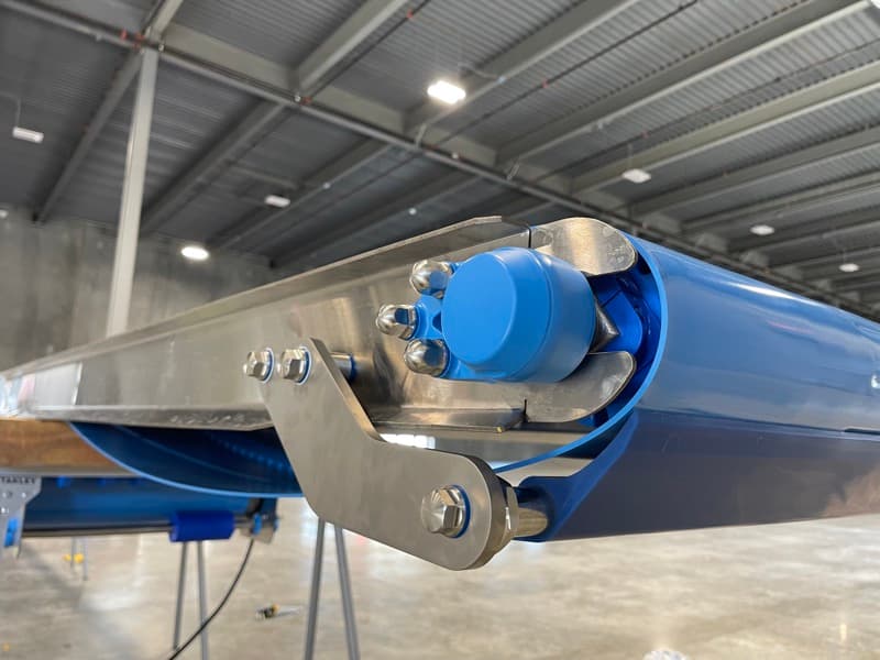 Drive end of a sanitary flat belt conveyor with sealed motor on a stainless frame
