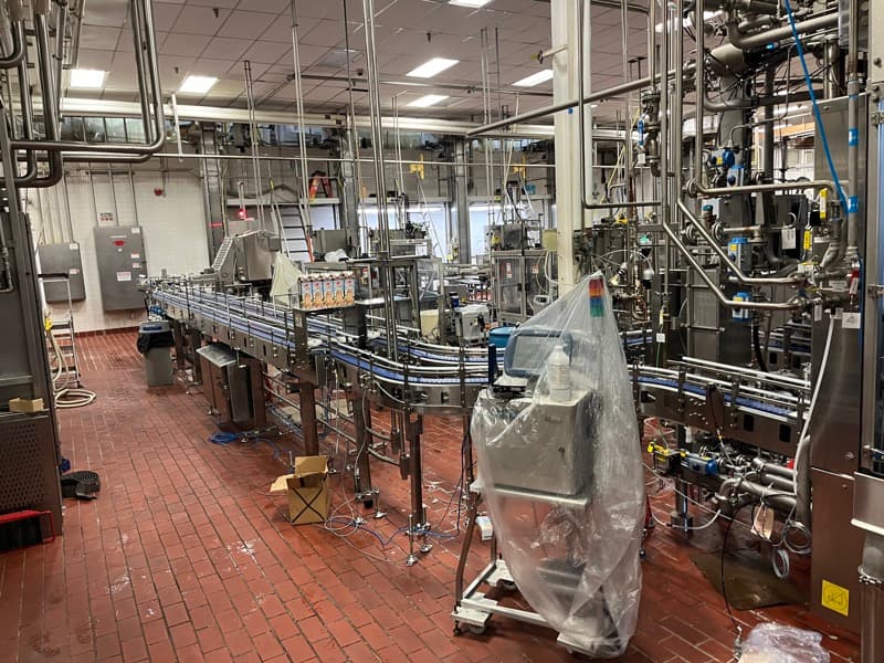 Modular belt conveyor system handling clamshell packaging in a sanitary production environment