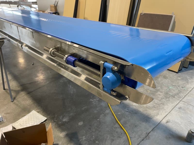 Blue flat belt conveyor with stainless take-up and tensioner at the tail end