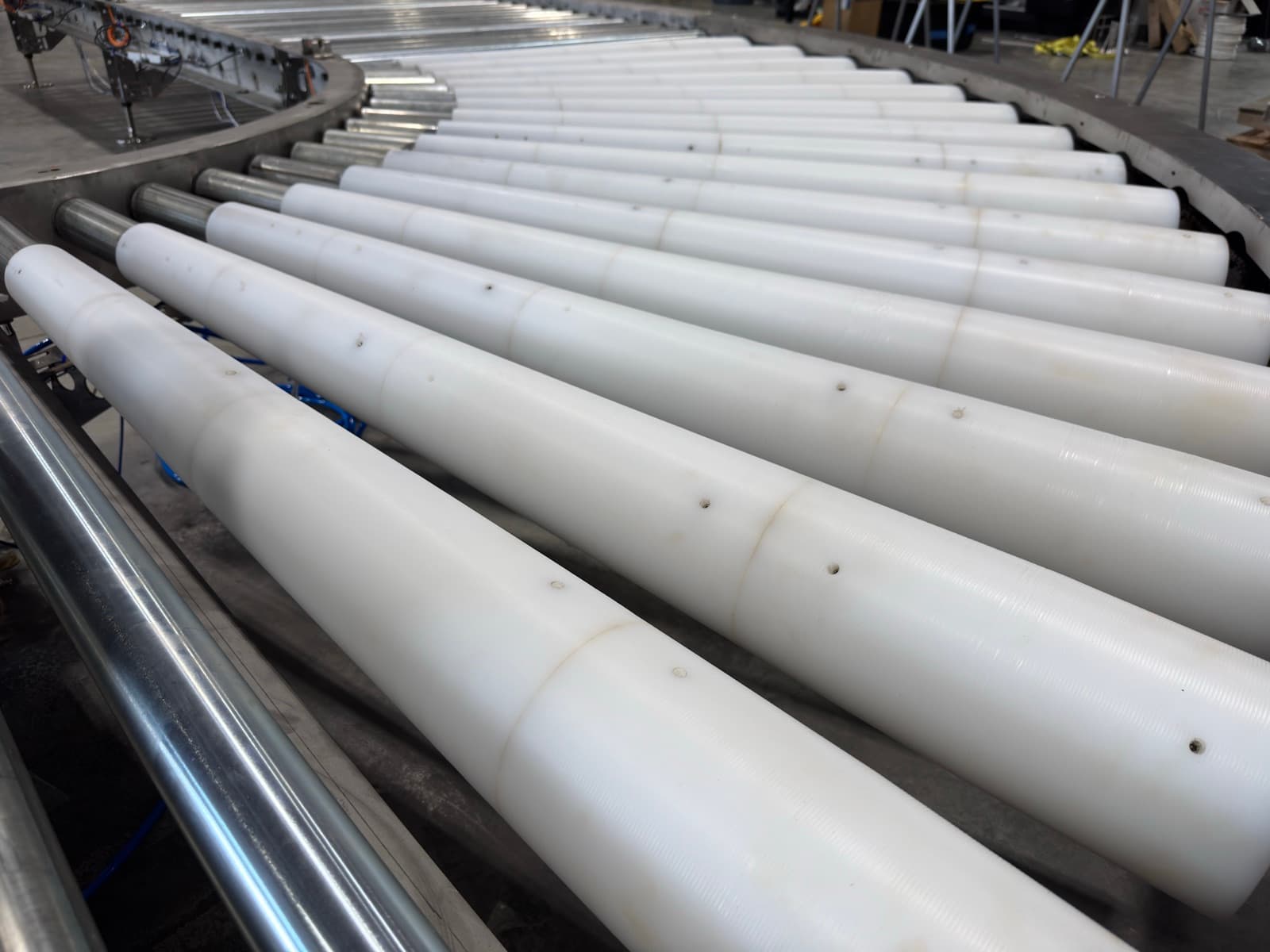 White tapered rollers of a stainless 24V MDR conveyor curve