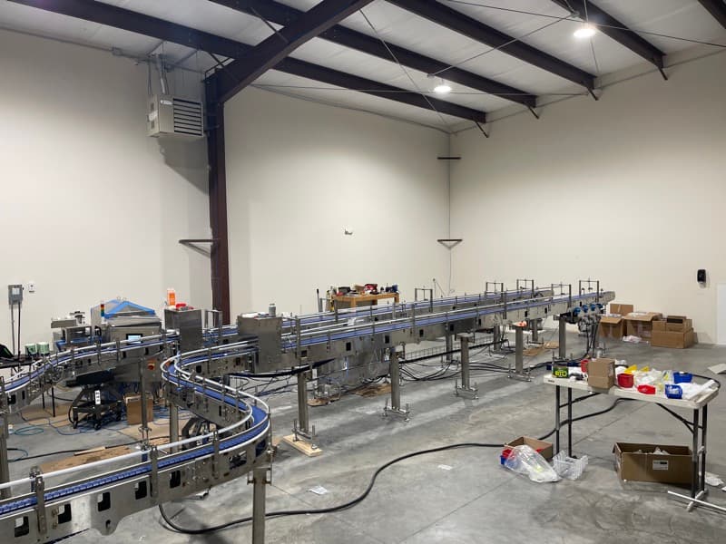 Long multi-lane sanitary modular belt line with guide rails staged in the AQS shop