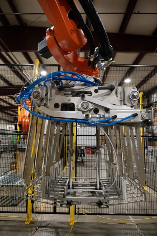 Close-up of KUKA robot arm with custom-machined stainless steel end effector